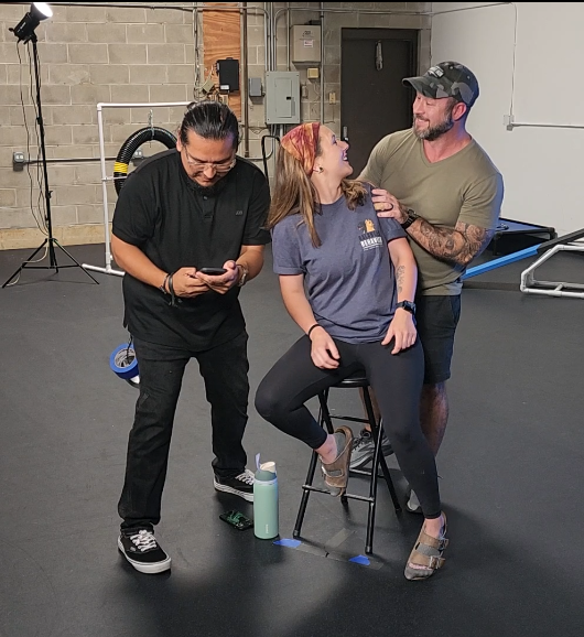 Brad and a client team planning together on set at a dog training facility